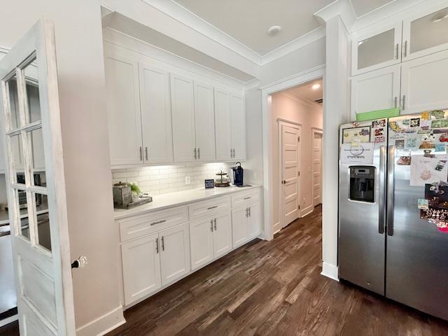  - kitchen with stainless steel fridge, ornamental molding, tasteful backsplash, white cabinets, and dark wood-style flooring