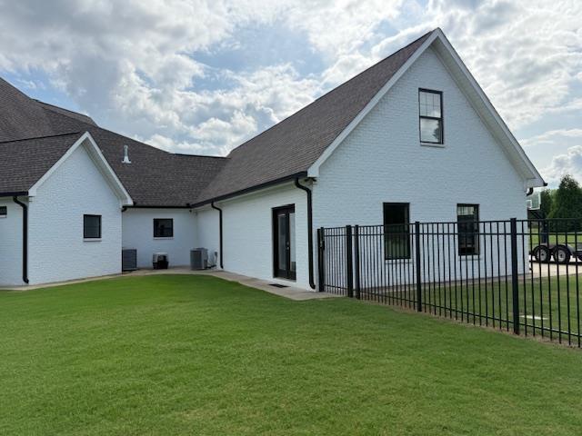  - rear view of property featuring central AC and a shingled roof