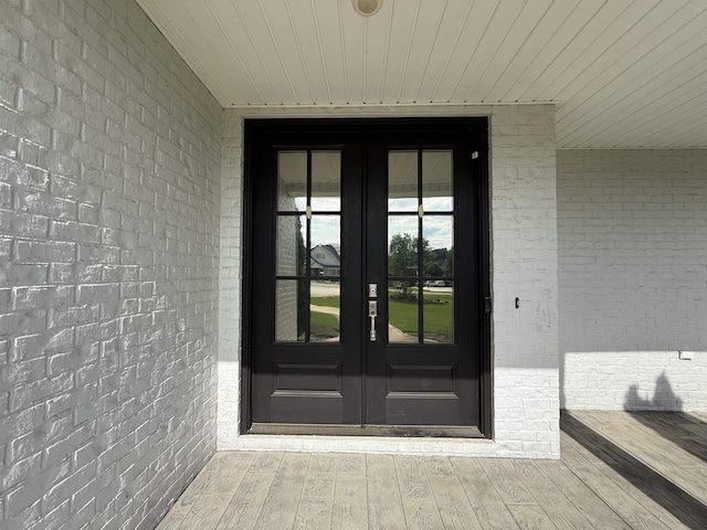  - view of exterior entry featuring french doors and brick siding