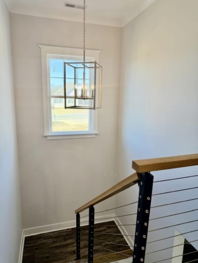  - stairway featuring wood finished floors, baseboards, and a chandelier