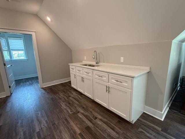  - bar area featuring a sink, dark wood-style flooring, baseboards, and vaulted ceiling