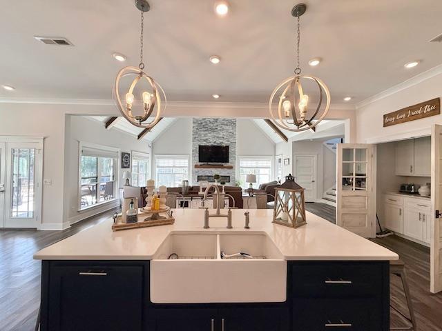  - kitchen featuring open floor plan, a chandelier, a sink, light countertops, and lofted ceiling