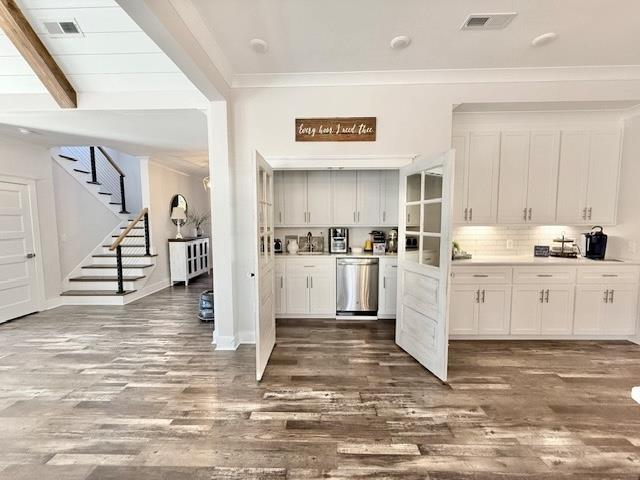  - kitchen featuring dishwasher, dark wood finished floors, white cabinetry, crown molding, and light countertops