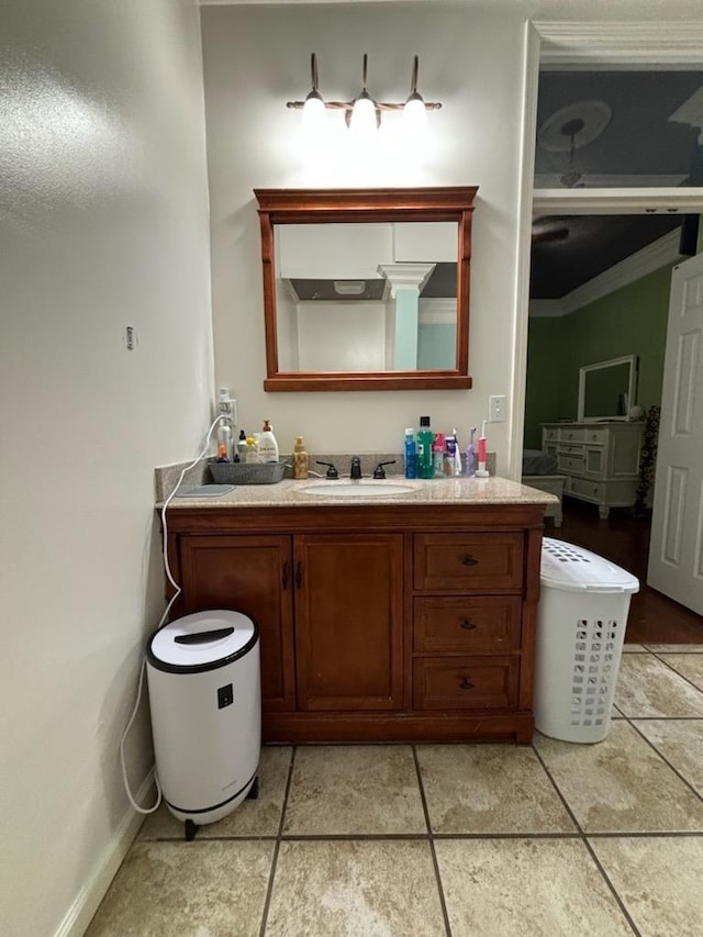 bathroom featuring tile patterned flooring, vanity, and crown molding