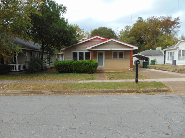 bungalow-style home featuring a porch and a carport