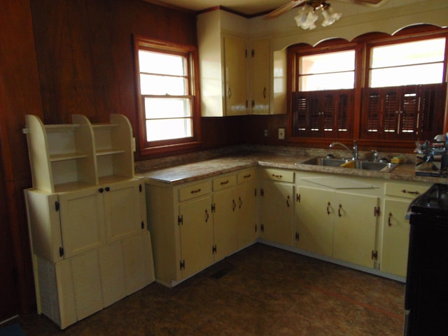 kitchen with ceiling fan, a healthy amount of sunlight, sink, and black / electric stove