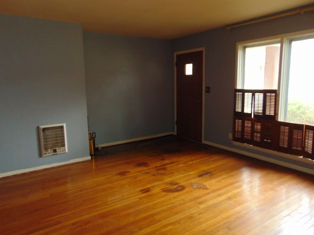 spare room with heating unit and hardwood / wood-style floors