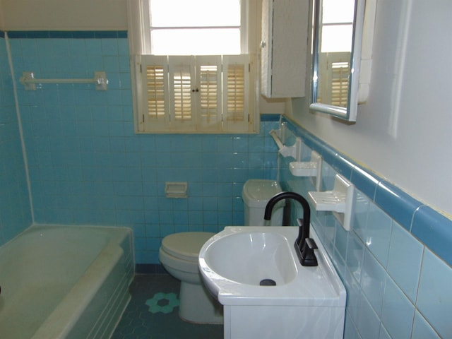 bathroom featuring a bathing tub, tile patterned flooring, tile walls, and vanity