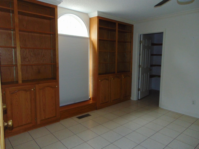 empty room featuring ceiling fan and crown molding