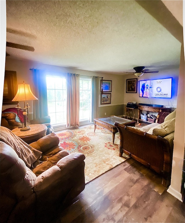 carpeted living room featuring a textured ceiling and ceiling fan