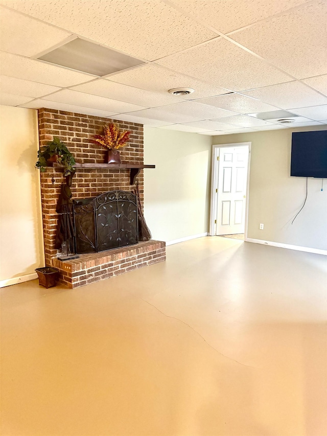 basement with a fireplace and a drop ceiling