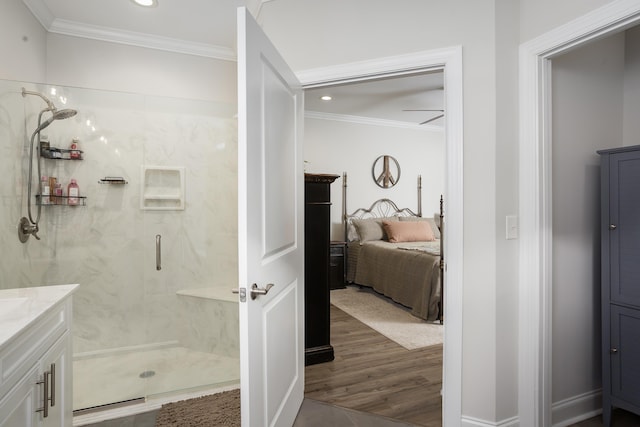  - ensuite bathroom with ornamental molding, vanity, a shower stall, wood finished floors, and recessed lighting