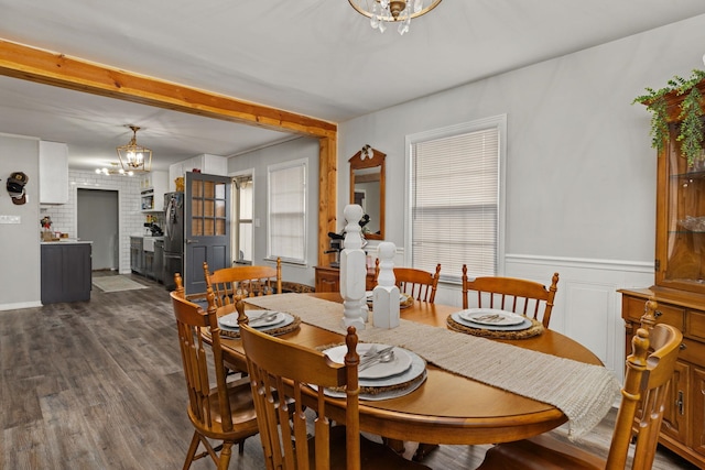 dining space featuring dark hardwood / wood-style flooring, plenty of natural light, and an inviting chandelier