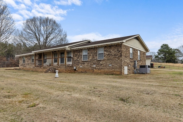 view of front facade featuring a front yard and central air condition unit