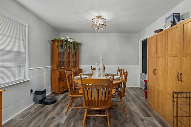 dining space featuring dark hardwood / wood-style floors and an inviting chandelier