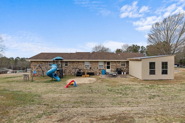 rear view of house with a lawn and a playground