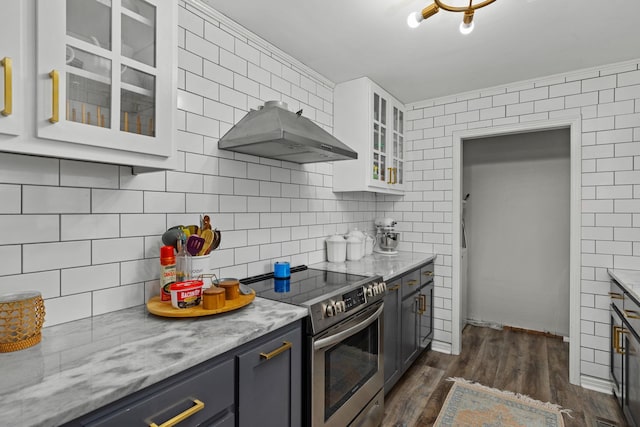 kitchen with gray cabinetry, backsplash, white cabinets, light stone counters, and electric stove