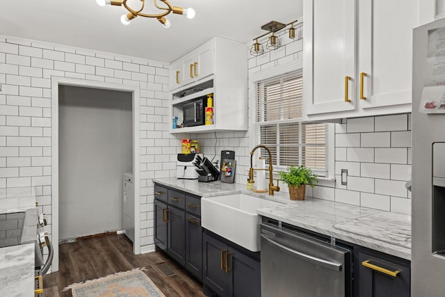 kitchen featuring sink, appliances with stainless steel finishes, white cabinetry, backsplash, and light stone counters