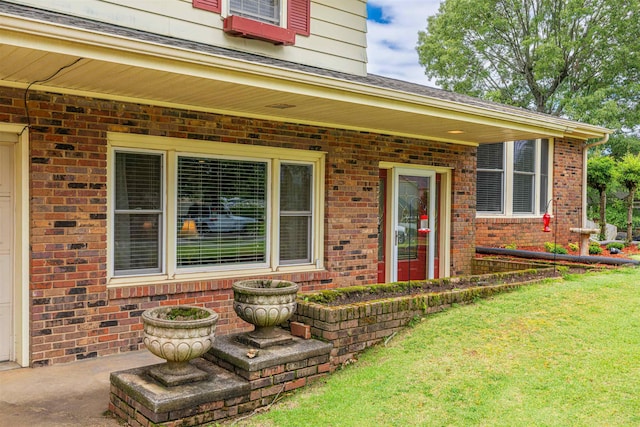  - entrance to property featuring brick siding, a lawn, and cooling unit
