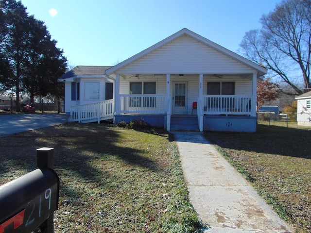 bungalow with covered porch and a front lawn