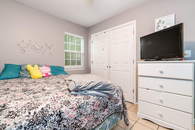  - bedroom featuring light tile patterned floors and a closet