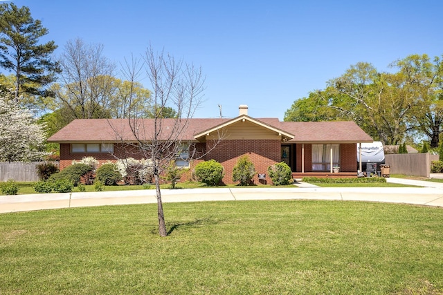 - ranch-style home featuring fence, a front lawn, and brick siding
