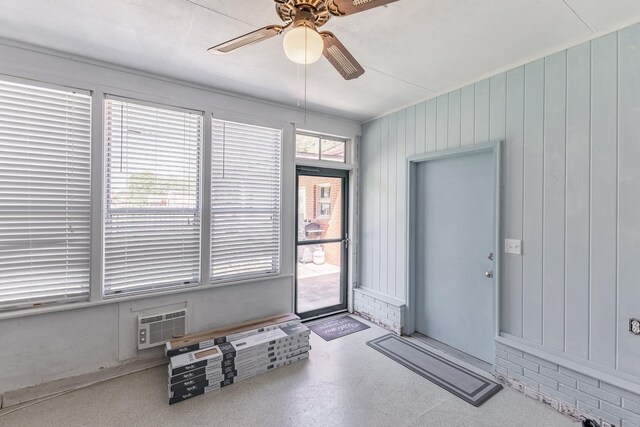  - interior space with wood walls, a wall mounted AC, and ceiling fan