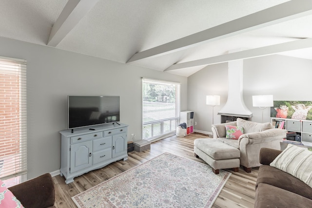  - living area featuring light wood-style floors, baseboards, and vaulted ceiling with beams