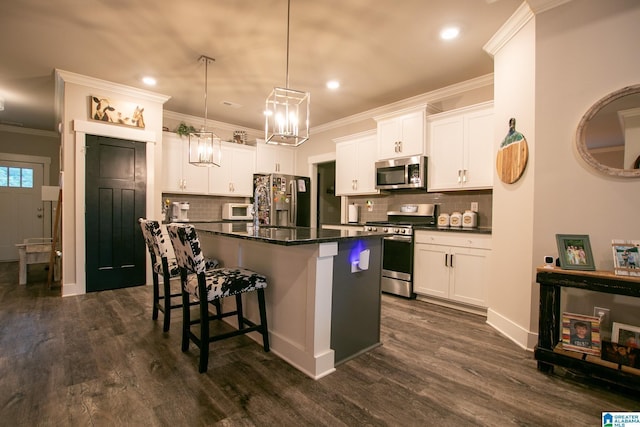  - kitchen with stainless steel appliances, a breakfast bar area, tasteful backsplash, a center island with sink, and crown molding