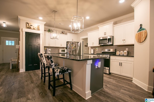  - kitchen with stainless steel appliances, dark countertops, a breakfast bar, a kitchen island with sink, and crown molding
