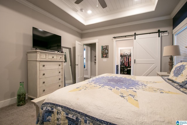  - carpeted bedroom with a raised ceiling, a barn door, crown molding, a spacious closet, and ceiling fan