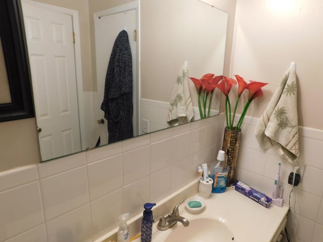 bathroom with tile walls, wainscoting, and vanity