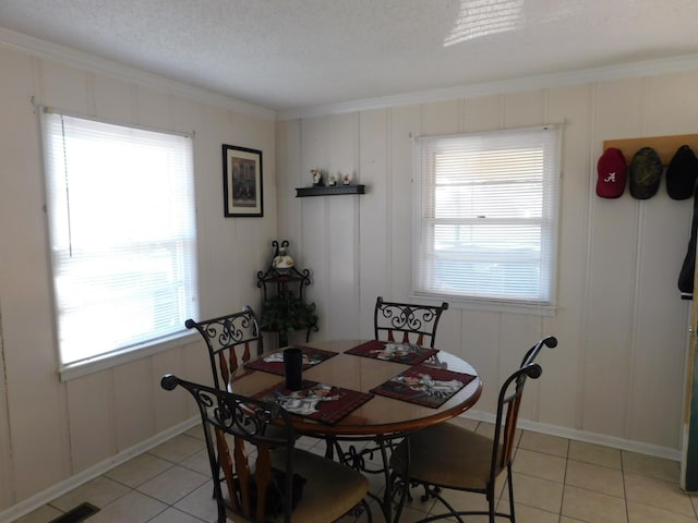 dining area with visible vents, a decorative wall, a textured ceiling, and light tile patterned floors