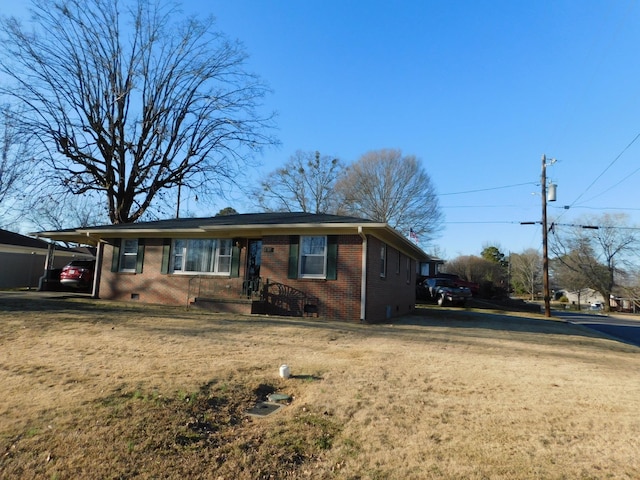 single story home with driveway, a front yard, an attached carport, and brick siding