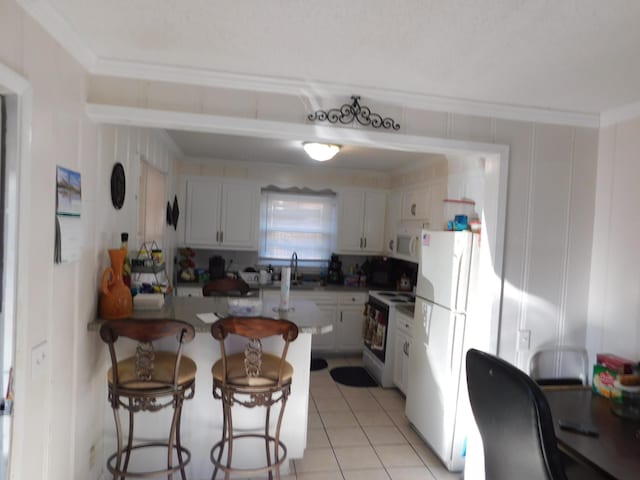 kitchen with light tile patterned floors, a peninsula, white appliances, a sink, and crown molding