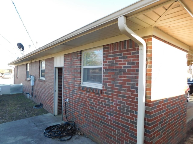 view of side of home featuring crawl space and brick siding