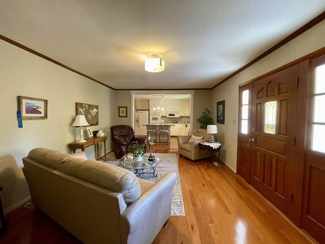  - living room with crown molding, light wood finished floors, a textured ceiling, and baseboards
