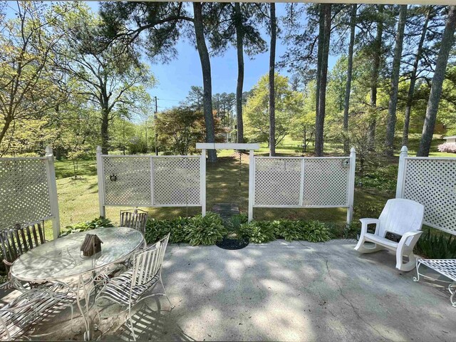  - view of patio / terrace featuring outdoor dining area and view of wooded area