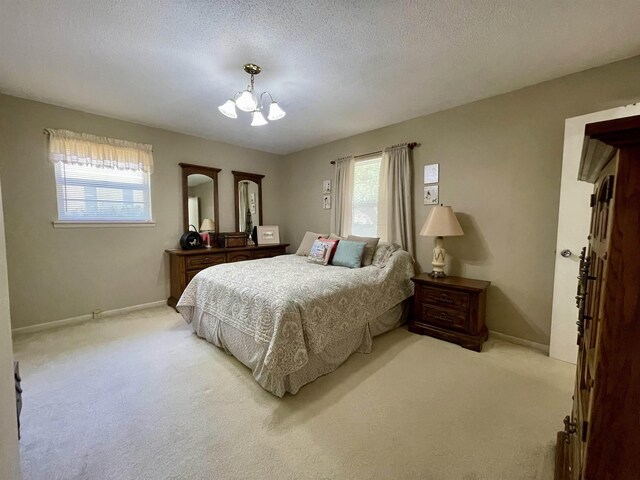  - bedroom with light colored carpet, a chandelier, baseboards, and a textured ceiling