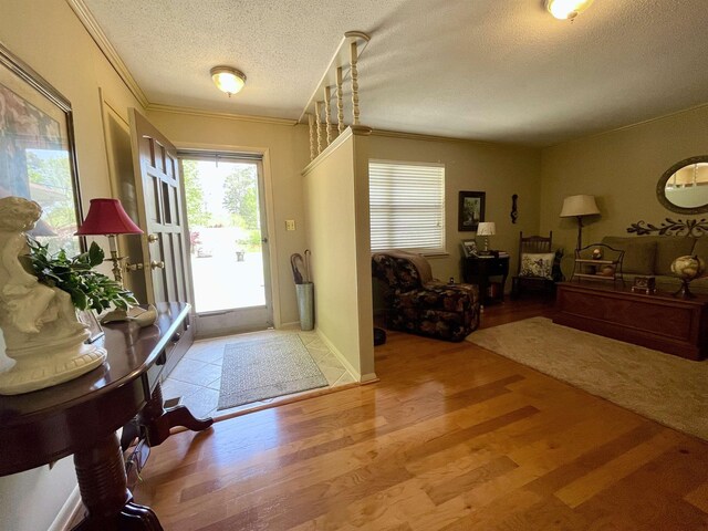  - foyer featuring a textured ceiling, wood finished floors, and crown molding