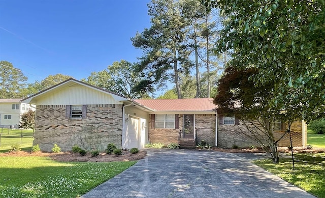  - ranch-style house with brick siding, a garage, a front lawn, concrete driveway, and metal roof