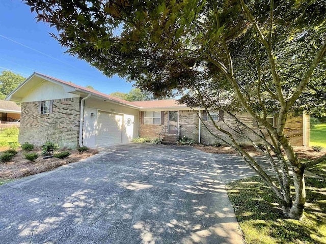  - ranch-style house featuring concrete driveway, brick siding, and a garage