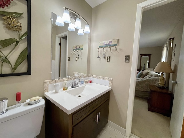 - bathroom with toilet, vanity, tile patterned flooring, and ensuite bath