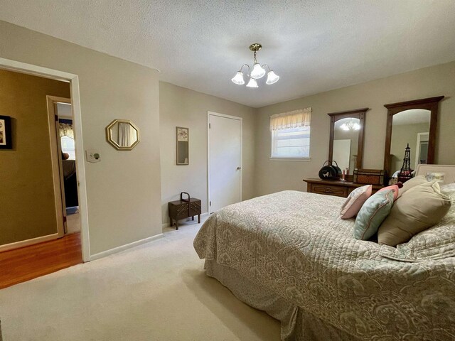  - bedroom with a chandelier, light carpet, and baseboards