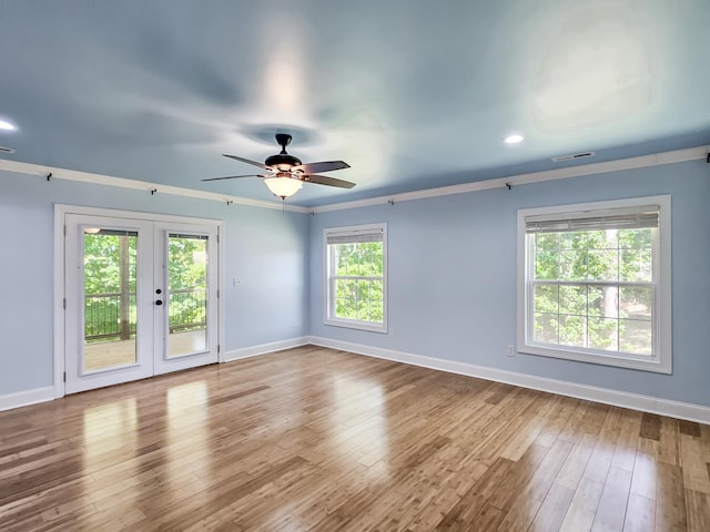 unfurnished room with hardwood / wood-style floors, plenty of natural light, and french doors