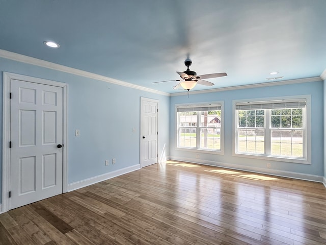 empty room featuring ceiling fan, light wood-type flooring, and crown molding