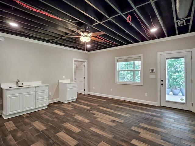 basement featuring ceiling fan, sink, and dark hardwood / wood-style floors