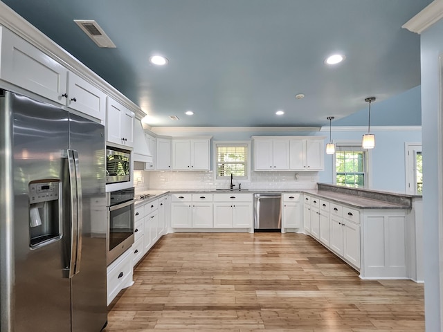 kitchen featuring white cabinetry, sink, hanging light fixtures, crown molding, and appliances with stainless steel finishes