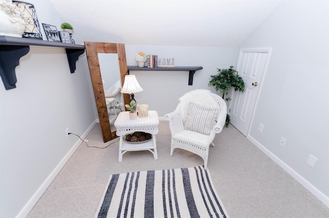 living area featuring carpet floors and vaulted ceiling