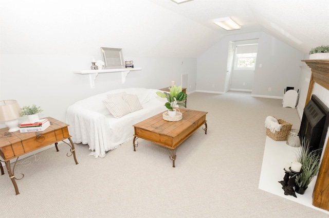 carpeted living room featuring a tiled fireplace and vaulted ceiling